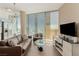 This living room has large windows, a brown leather couch, and a glass table with amazing city views at 3722 Las Vegas Blvd # 3209, Las Vegas, NV 89158