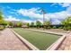 Beautifully maintained bocce ball court features lush turf, stylish lighting, and pristine landscaping against a backdrop of blue skies at 412 Middlestone Ave, Henderson, NV 89011