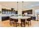 A kitchen features a large island with granite countertops and dark wood cabinetry and seating at 412 Middlestone Ave, Henderson, NV 89011