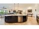 Open kitchen boasts dark cabinets, granite counters, stainless steel appliances, and large island at 412 Middlestone Ave, Henderson, NV 89011