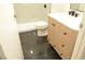 Recently remodeled bathroom with a black tiled floor, wood vanity, and tiled shower at 4277 Rimcrest Rd, Las Vegas, NV 89121