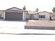 Charming single-story home with a gray garage door and desert landscaping at 4277 Rimcrest Rd, Las Vegas, NV 89121