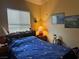Bedroom with blue bedspread, wood furnishings, and natural light at 4620 Ventana Rey St, North Las Vegas, NV 89081