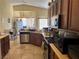 Functional kitchen featuring wood cabinetry, stainless steel appliances, and tiled floor at 4620 Ventana Rey St, North Las Vegas, NV 89081