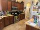 This is a full kitchen featuring wood cabinetry, stainless steel appliances, and tiled floor at 4620 Ventana Rey St, North Las Vegas, NV 89081