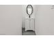 Cozy half bathroom with modern white vanity and oval mirror with black hardware at 4825 Stillwater Ave, Las Vegas, NV 89110