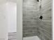 Modern shower with gray tiled walls, updated hardware and white shower base at 4825 Stillwater Ave, Las Vegas, NV 89110