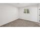 A simple bedroom featuring neutral carpet and a window at 4825 Stillwater Ave, Las Vegas, NV 89110