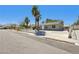 Full street view of a desert landscaped home with secure driveway and mature trees at 4825 Stillwater Ave, Las Vegas, NV 89110