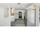 Stylish kitchen with stainless steel appliances, white cabinets, breakfast bar and light grey flooring at 4825 Stillwater Ave, Las Vegas, NV 89110