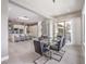 Open-concept dining area with modern chandelier, a glass table, and a view of the kitchen and living space at 5 Clear Crossing Trl, Henderson, NV 89052