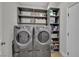 Laundry room with front-load washer, dryer, and storage shelving at 530 Sonoma Range St, Las Vegas, NV 89138