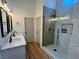 Modern bathroom featuring double sink vanity with marble countertop and glass-enclosed shower with black hardware at 5600 Nimes Ave, Las Vegas, NV 89141