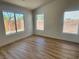 Bright, empty bedroom with wood floors and three windows overlooking the backyard at 5600 Nimes Ave, Las Vegas, NV 89141