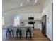 Bright kitchen features white cabinetry, stainless steel appliances, and a quartz countertop island with seating at 5600 Nimes Ave, Las Vegas, NV 89141