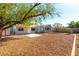Large backyard featuring low maintenance rock, patio area, and mature tree, with ample space for entertaining at 5800 Auborn Ave, Las Vegas, NV 89108
