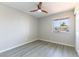 Well-lit bedroom with gray wood-look flooring, ceiling fan, and a window view of the neighborhood at 5800 Auborn Ave, Las Vegas, NV 89108