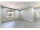 Bright living room featuring gray plank flooring, neutral paint, and a large window at 5800 Auborn Ave, Las Vegas, NV 89108