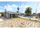View of the backyard with covered patio, pool with rock border, and solar panels on the home's roof at 5809 Pebble Beach Blvd, Las Vegas, NV 89108