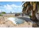 Backyard features a unique in-ground swimming pool surrounded by a rock and a tropical palm tree at 5809 Pebble Beach Blvd, Las Vegas, NV 89108