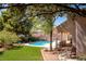 Expansive backyard features artificial grass, desert landscaping, pool and covered patio at 6293 Pavestone Ln, Las Vegas, NV 89142