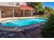 Inviting backyard features a swimming pool, covered patio, and well-maintained landscaping at 6293 Pavestone Ln, Las Vegas, NV 89142