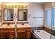 Bathroom includes double vanities, decorative lighting, a bathtub, and a tiled accent wall at 6293 Pavestone Ln, Las Vegas, NV 89142