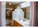 Bathroom featuring double sinks, bathtub/shower combo with glass door, vanity mirror, and tile accents at 6293 Pavestone Ln, Las Vegas, NV 89142