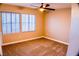 Neutral bedroom featuring two windows, carpet flooring, and a ceiling fan with light at 6293 Pavestone Ln, Las Vegas, NV 89142