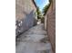 Spacious side yard featuring a long driveway with block wall and access gate at 6293 Pavestone Ln, Las Vegas, NV 89142