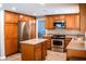Stylish kitchen with stainless steel appliances, wood cabinets, island, and plenty of counter space at 6293 Pavestone Ln, Las Vegas, NV 89142