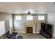 Living room featuring a fireplace, windows, ceiling fan and adjacent furniture at 6293 Pavestone Ln, Las Vegas, NV 89142