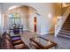 Spacious living room featuring an open floor plan, hardwood floors, and staircase to the upper level at 6293 Pavestone Ln, Las Vegas, NV 89142