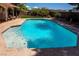 A large swimming pool is surrounded by a patio and landscaping, providing a relaxing outdoor space at 6293 Pavestone Ln, Las Vegas, NV 89142