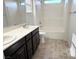 A dual-sink vanity sits across from a shower-tub combo in this neutral colored bathroom at 664 Forest Peak St, Henderson, NV 89011