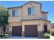 Two-story home featuring a two car garage, landscaped yard, and classic desert architecture at 664 Forest Peak St, Henderson, NV 89011