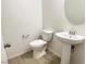 The powder room is clean and modern, with a pedestal sink and elongated toilet at 664 Forest Peak St, Henderson, NV 89011