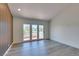Bright living room featuring wood floors, an accent wall, and glass doors to the balcony at 7132 Mission Hills Dr, Las Vegas, NV 89113