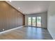 Bright living room featuring wood floors, an accent wall, and glass doors to the balcony at 7132 Mission Hills Dr, Las Vegas, NV 89113
