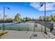 Outdoor tennis court featuring well-maintained courts, lighting and mature trees at 7132 Mission Hills Dr, Las Vegas, NV 89113