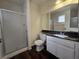 Well-lit bathroom with a shower, toilet, vanity with a dark countertop, and a large mirror at 725 Brick Dr, Henderson, NV 89002