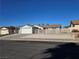 Single story home with desert landscaping, white garage door and blue roof at 725 Brick Dr, Henderson, NV 89002