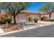Exterior view of the home featuring a tile roof, two-car garage, desert landscaping, and a private entry gate at 731 Appletree Ln, Mesquite, NV 89027
