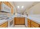 Functional kitchen area with wooden cabinetry, white appliances, and skylights for natural light at 731 Appletree Ln, Mesquite, NV 89027