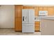 Kitchen featuring white appliances, wooden cabinetry, and tiled flooring at 731 Appletree Ln, Mesquite, NV 89027