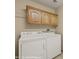 Bright laundry room featuring a white washer and dryer set, and light wood cabinets at 731 Appletree Ln, Mesquite, NV 89027