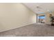 Spacious living room with carpet flooring and sliding door to balcony at 731 Appletree Ln, Mesquite, NV 89027