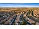 Expansive aerial view of a neighborhood featuring well-maintained homes and desert landscaping with a city skyline in the background at 741 Canary Wharf Dr, Las Vegas, NV 89178