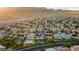 This aerial view showcases a community of homes with pools and desert landscaping nestled against a backdrop of scenic mountains at 741 Canary Wharf Dr, Las Vegas, NV 89178