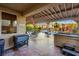 Spacious covered patio with an outdoor kitchen area, pool view and plenty of seating for entertaining guests at 741 Canary Wharf Dr, Las Vegas, NV 89178